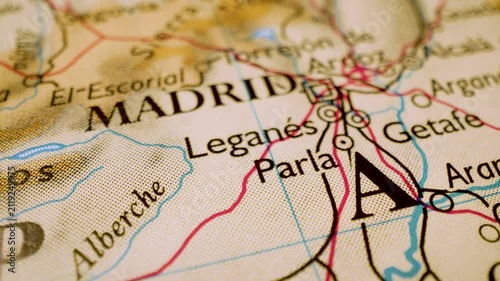 Gliding macro view over atlas map leading to Madrid, Spain