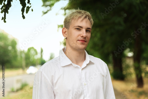 Portrait of handsome man wearing white shirt in park