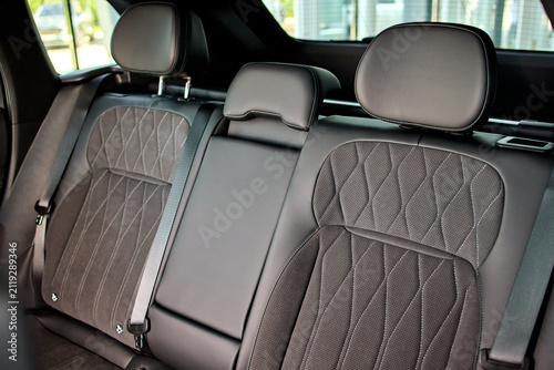 Canvastavla Rear leather car seats with center armrest, three headrests, visible seatbelt bu