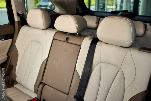 Obraz na plátně Rear leather car seats with center armrest, three headrests, visible seatbelt bu