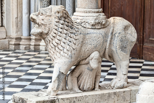 Close-up of architectural details of a historic church in Bergamo. Natural sunlight highlights the carved stone, craftsmanship and rich texture of the sacred architecture, showcasing Italian artistic 