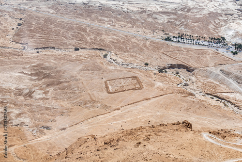 View  from top station of cable car to remains of Roman legionary camps at foot of mountain with ruins of Masada fortress in southern Israel near Arad