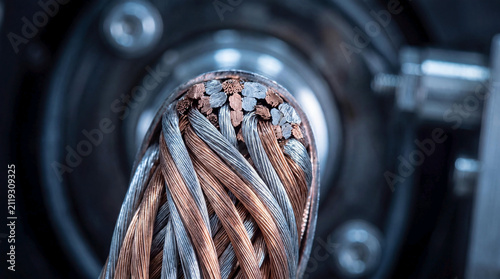 Close-up macro shot of industrial copper and aluminum electrical wire strands inside a manufacturing factory equipment