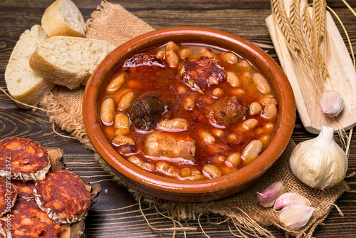 Quadro su tela Traditional Spanish fabada stew served in a clay bowl with white beans, chorizo,