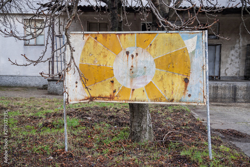 Rusted metal sign outside an old building.