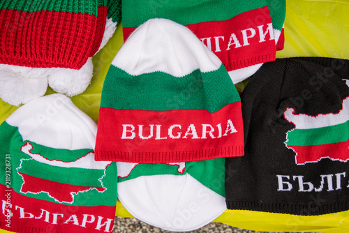 Knit beanie caps in the colors of the Bulgarian flag at an outdoor market.