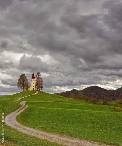 Undulating dirt trail going uphill to the Baroque, XVII c.Saint Thomas church (Cerkev svetega Tomaza) in Gorenji Vrsnik village. Idrija-Slovenia-189