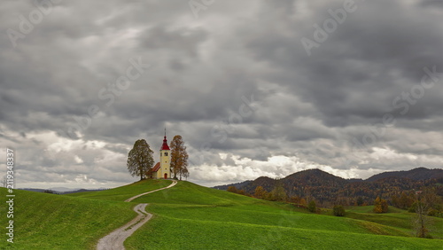 Undulating dirt trail going uphill to the Baroque, XVII c.Saint Thomas church (Cerkev svetega Tomaza) in Gorenji Vrsnik village. Idrija-Slovenia-190