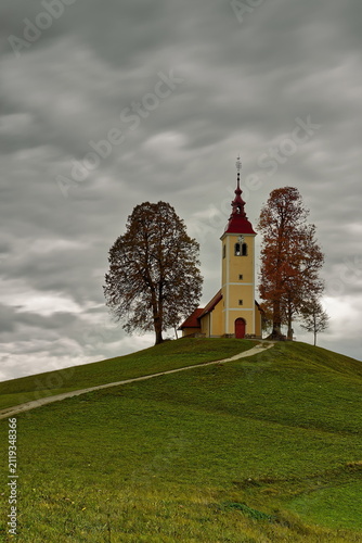 Undulating dirt trail going uphill to the Baroque, XVII c.Saint Thomas church (Cerkev svetega Tomaza) in Gorenji Vrsnik village. Idrija-Slovenia-196