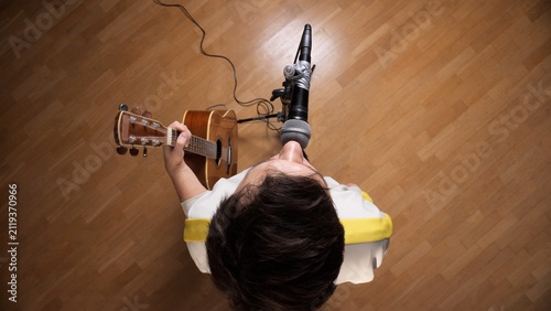 Foto Musicians performing solo, singing into a microphone while playing an acoustic g