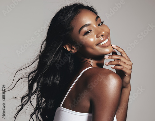 Stunning Model with Luminous Skin and Flowing Black Hair Smiling Softly