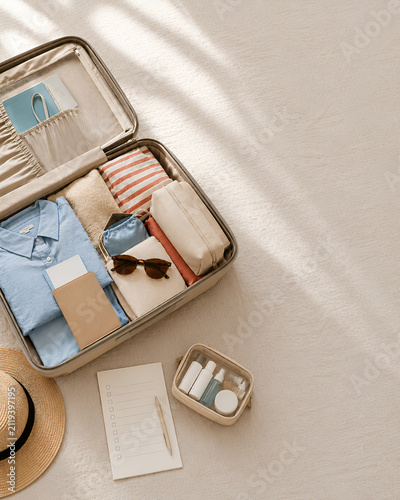 Organized travel packing flat lay with open suitcase and toiletries