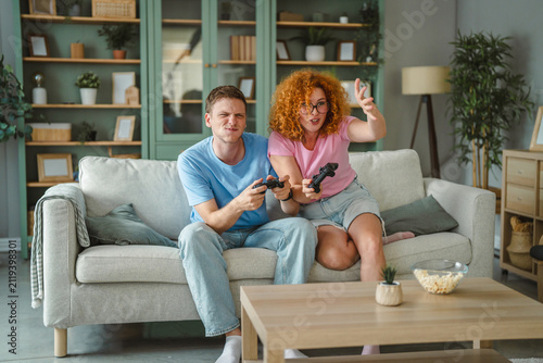 Obraz na plátně Couple enjoying competitive video gaming at home