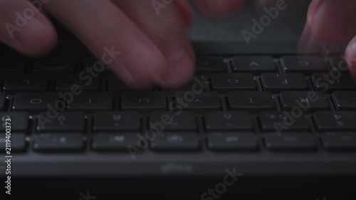 Close-up timelapse male hands typing rapidly on keyboard with motion blur, camera smoothly slides parallel to keys. Dynamic footage of remote work, business activity and digital workflow indoors