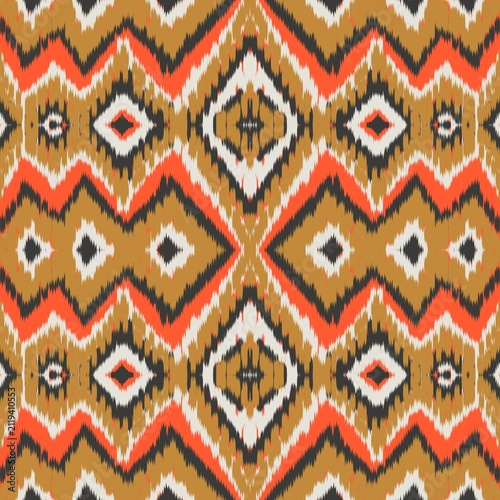 Seamless ethnic ikat pattern with bold gold, charcoal grey, and orange geometric diamond motifs on an ivory accent. Tribal fabric design perfect for bohemian prints, wallpaper, and creative decor.