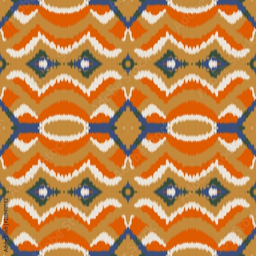 Seamless ethnic ikat pattern with bold orange, blue, and gold geometric wave motifs on an ivory accent. Tribal fabric design perfect for bohemian prints, wallpaper, and creative decor.