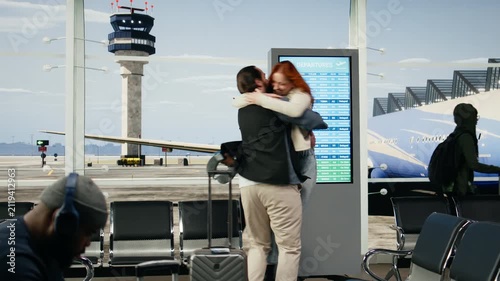 Boyfriend and girlfriend reunite in an airport terminal with hugs and kisses after flight arrival, expressing affection and joyful connection during an emotional homecoming and romantic travel story.
