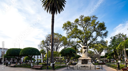Historic monument in a beautiful public plaza honoring a liberator surrounded by tall palm trees during a peaceful independence day celebration