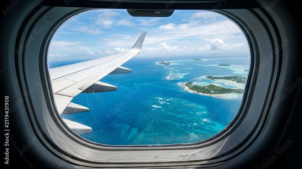 Fototapeta premium Aerial view of tropical islands and turquoise ocean from a commercial airplane window during flight