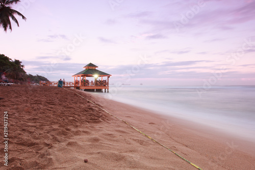 Cuadro en lienzo Long exposure view of a tropical beach shoreline at dusk with a wooden gazebo pi