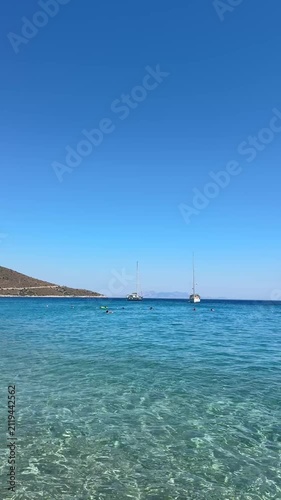 Palamutbükü Datça, endless deep blue sea, crystal-clear water, sailboat near the shore, rocky Mediterranean coastline, serene summer atmosphere
