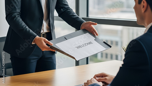 Manager welcoming a new employee with a folder