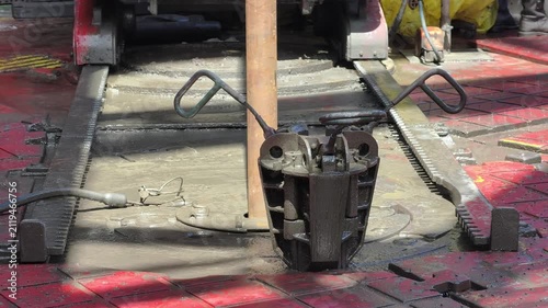 Drill pipe slips on the rotary table while drilling oil well and pipe being rotated. Oilfield related footage