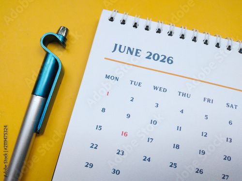 June 2026 calendar page with a modern pen on a yellow background