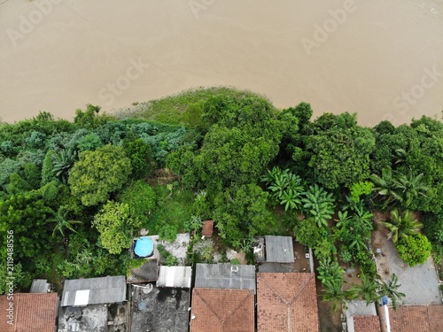 Construções e a área de preservação permanente na margem do Rio Ribeira de Iguape, na divisa entre os estados de São Paulo e Paraná, Brasil, em imagem aérea obtida com sobrevoo de drone.