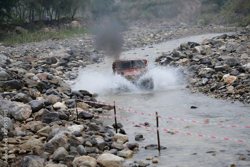 Obraz na płótnie Autocross Racing Vehicle Splashing Through River Course