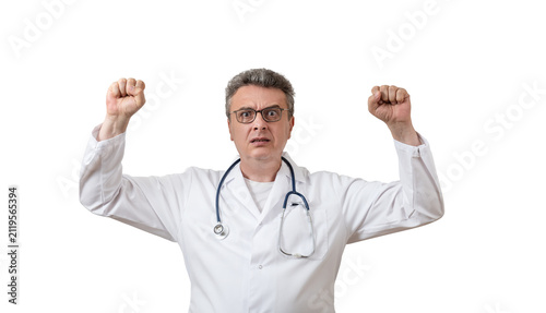 Obraz na płótnie A middle-aged male doctor in a white coat, with an angry expression and an emotional gesture, against a white background