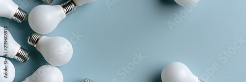 Banner flat lay white frosted light bulbs arranged on light blue background with copy space, creative inspiration energy business concept top view