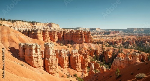 Vast canyon landscape with towering sandstone formations under a clear sky