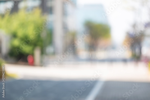 Abstract blurred background of modern city plaza with green trees