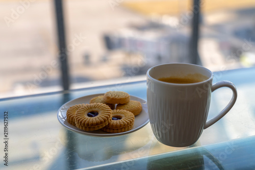 Coffee and cookies on a glass table.