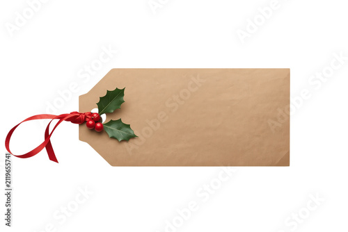 Blank kraft holiday gift tag with red ribbon and holly isolated on transparent background