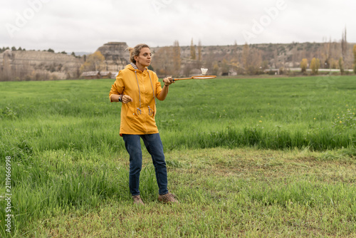 Obraz na plátne Woman badminton field recreational game activity rural landscape yellow jacket