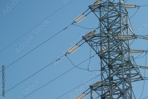 Quadro su tela High voltage transmission tower carrying multiple power lines across clear blue