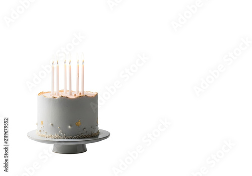 Elegant single-tiered cake, smooth white icing, subtle gold flakes, flickering candles on a stand, studio setting with copy space, soft lighting. Corporate milestone celebration atmosphere