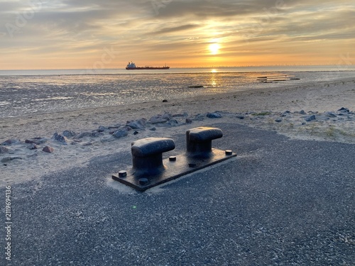 Poller an der Strandpromenade in Cuxhaven im Sonnenaufgang an der Nordsee