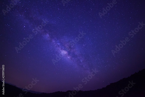 Silhouette of mountain at Phuhinrongkla national park and night sky space background, Starry universe in dark blue sky, Milky way galaxy with stardust field in deep universe