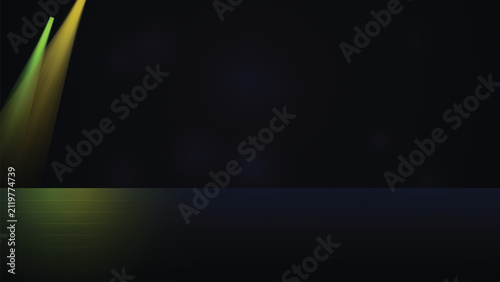 Green and yellow spotlight beams on dark stage background with spotlight