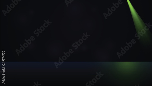 Green spotlight beam from top right on empty dark background with spotlight