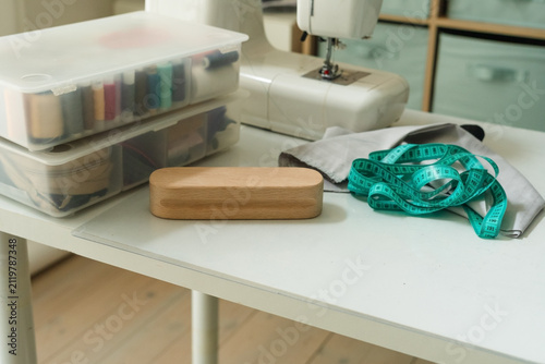 Фотография Pressing board for ironing seams and a sewing machine with fabric on a table for professional steam preparation