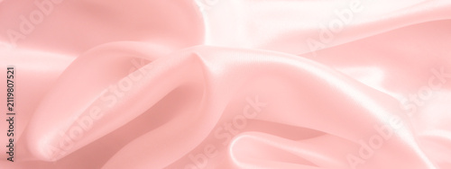 Soft pink silk satin fabric background with gentle folds