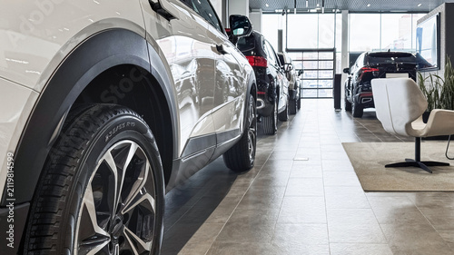 Car display in a dealership showing a row of cars for sale in a modern building