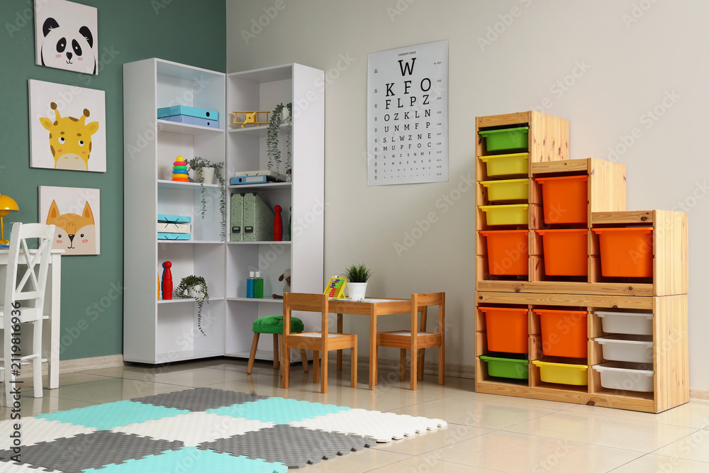 Obraz premium Interior of pediatricians office with table, shelf unit and toys