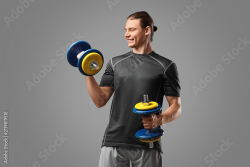 Sporty young man with dumbb...