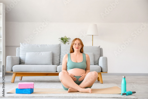 Sporty pregnant woman sitti...
