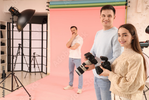Photographers with cameras and model during master class in studio